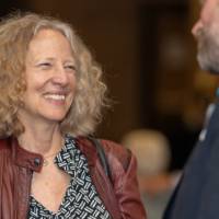 Provost Drake smiles while speaking with a staff member